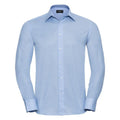 The Russell Collection's J922M is showcased against a white background, featuring a light blue, long-sleeve dress shirt design with a classic collar and button-down front. It offers a tailored fit and includes buttoned cuffs for added style.