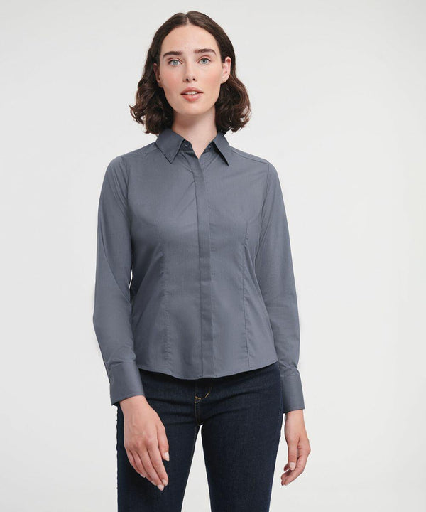 A person with a neutral expression is wearing a Russell J924F grey button-up shirt and dark jeans, standing against a plain white background.