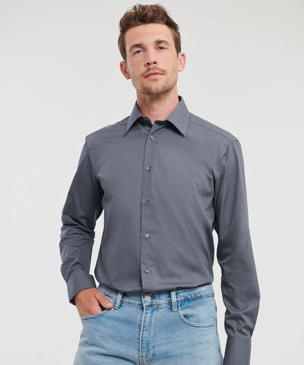 A man in a Russell J924M gray button-up shirt and blue jeans stands with one hand in his pocket against a plain background.