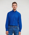Man with short brown hair wearing a Russell J932M bright blue dress shirt and blue jeans, standing against a plain white background.