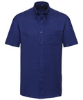 The product is a front-view of a short-sleeved, blue button-down shirt with a breast pocket from the Russell Collection, model J933M.