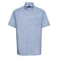 A Russell Collection J933M light blue short-sleeve button-up shirt, featuring a collar and a single chest pocket, displayed against a plain white background.