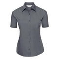 Introducing the J935F from Russell Collection: a short-sleeved, button-up shirt in a solid dark gray color. This stylish shirt features a classic collar and a convenient pocket on the left chest, showcased against a plain white background.