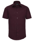 The Russell Collection's J947M features a burgundy short-sleeve, button-up shirt with a collar, showcased against a white background.