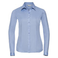 Introducing the Russell Collection J962F: A long-sleeve button-up shirt in light blue, featuring a collar, all displayed on a white background.