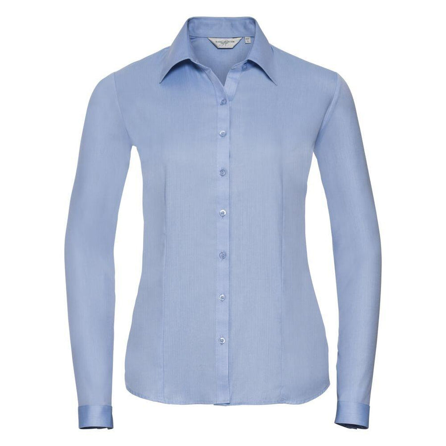 Introducing the Russell Collection J962F: A long-sleeve button-up shirt in light blue, featuring a collar, all displayed on a white background.