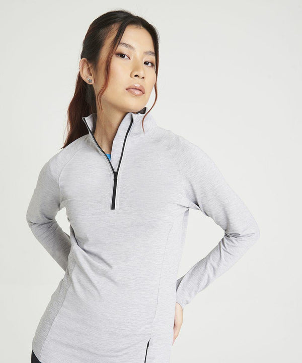 Person wearing a light gray AWDis Just Cool JC035 long-sleeve zip-up top, standing with hands on hips against a plain white background.