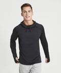 A person standing and smiling, wearing a black long-sleeve hoodie and light gray pants (JC037 by AWDis Just Cool), against a plain white background.