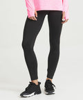 Person wearing an AWDis Just Cool JC070, black leggings, and black athletic shoes is standing against a neutral background.