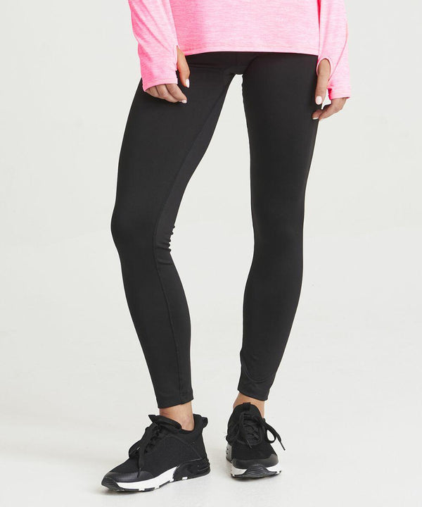 Person wearing an AWDis Just Cool JC070, black leggings, and black athletic shoes is standing against a neutral background.