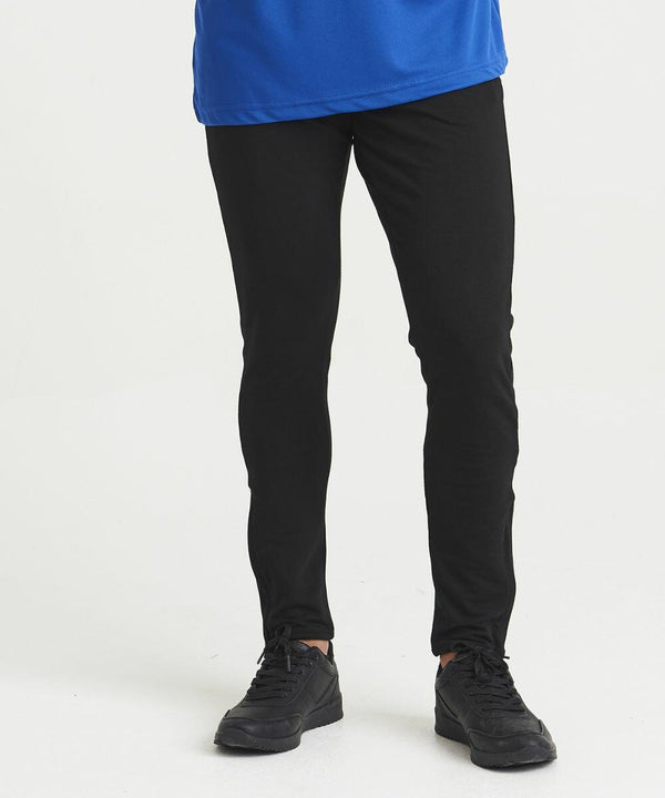 Person wearing black pants, black shoes, and a blue JC082 shirt from AWDis Just Cool standing on a white background.