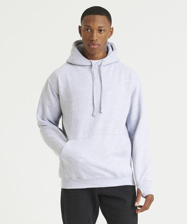 A person is standing against a plain background, wearing an AWDis Just Hoods JH020 light gray hooded sweatshirt and black jeans.