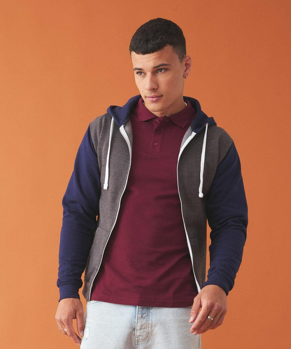 Man with short hair in a maroon polo shirt and an AWDis Just Hoods JH059 stands against an orange background.