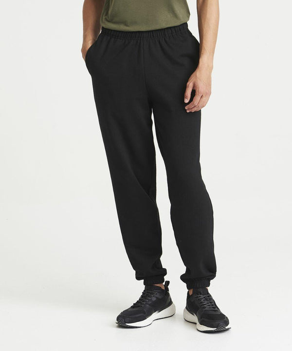 Person wearing AWDis Just Hoods JH072 black jogger pants and black sneakers.