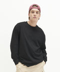 A young person wearing an AWDis Just T's JT019, light khaki pants, and a pink baseball cap stands against a plain white background.