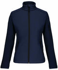 Navy blue zip-up jacket with a high collar, two zippered side pockets, and a zippered pocket on the left sleeve, displayed on a white background. The product is the KB400 by Kariban.