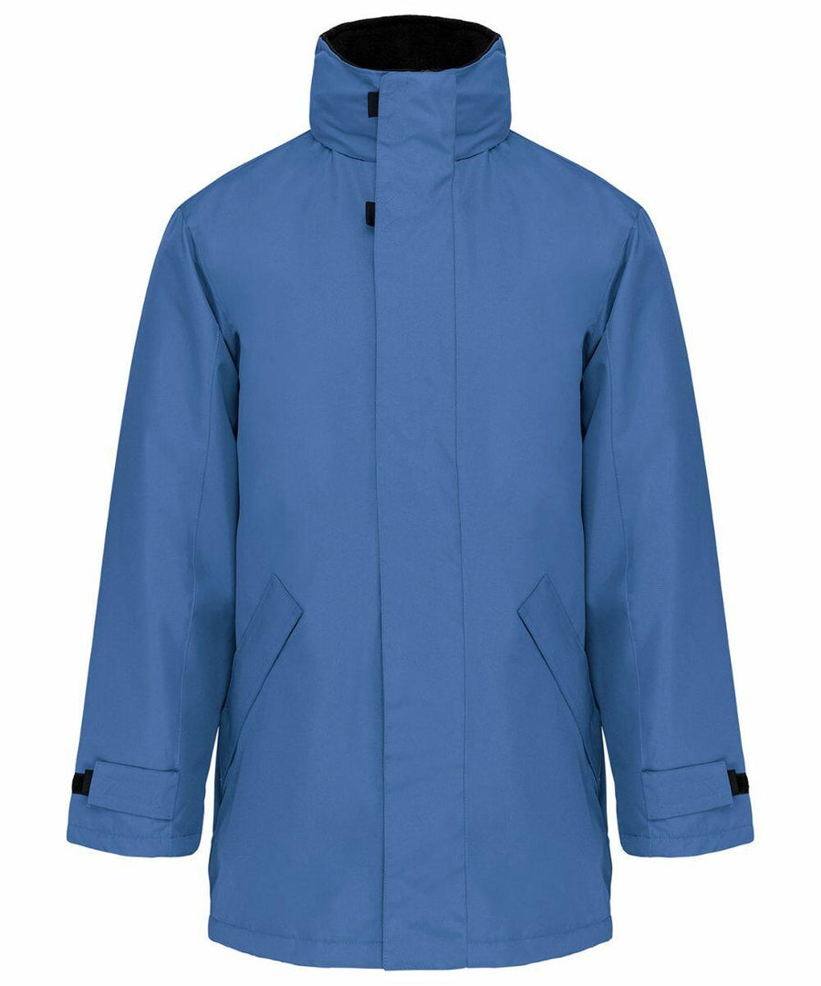 A blue, long-sleeve winter coat with a high collar and adjustable cuffs, KB677 by Kariban.
