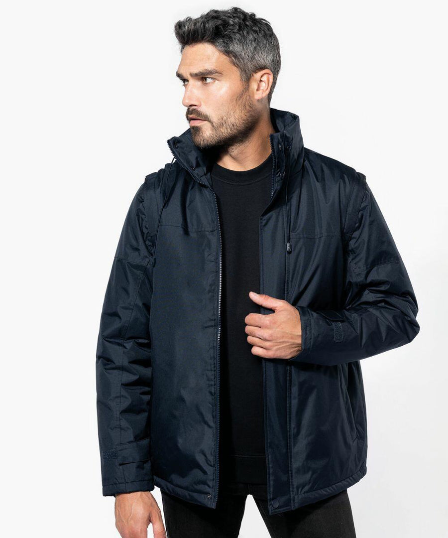 A man with short dark hair and a beard wearing a Kariban KB693 over a black shirt looks to his left.