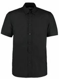 The KK100 by Kustom Kit is a short-sleeved black button-up shirt with a collar, showcased against a plain white background.