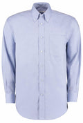 Introducing the KK105 shirt from Kustom Kit: a light blue, long-sleeved button-up with a buttoned collar. It includes a single chest pocket on the left side and is elegantly displayed against a white background.