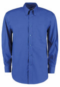 The Kustom Kit KK105 is a long-sleeve, blue button-up shirt featuring a collar and a chest pocket, presented neatly against a plain white background.