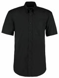 KK109 by Kustom Kit is a short-sleeved, button-up black shirt featuring a left chest pocket, displayed on a white background.