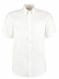 The product, KK109 by Kustom Kit, is a white short-sleeve button-up shirt featuring a collar and a single chest pocket, showcased against a plain white background.