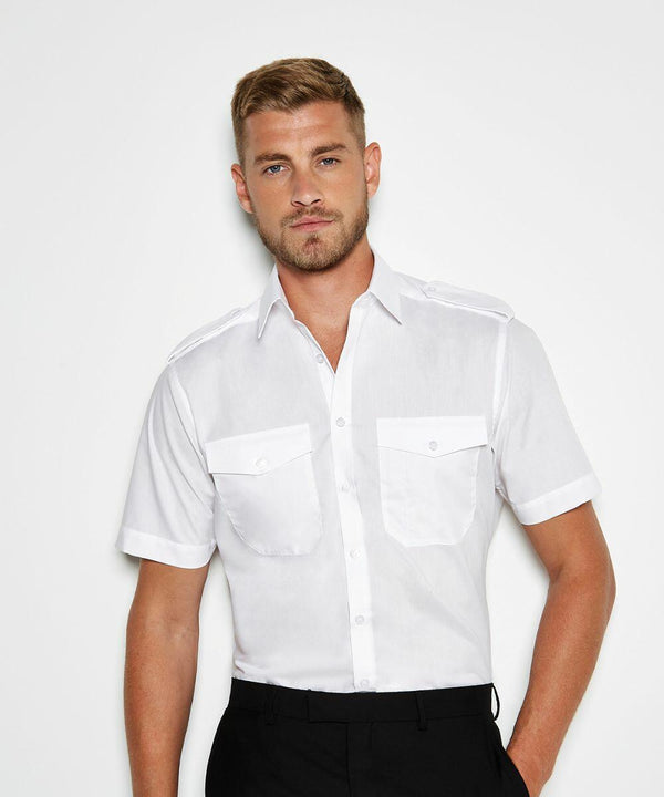 Man with short light brown hair wearing a Kustom Kit KK133 white short-sleeve button-up shirt with two chest pockets, standing against a plain white background.