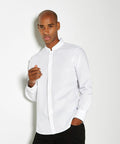 A man stands against a white background wearing a white long-sleeve button-up shirt and black pants. He has a neutral expression and his right hand is raised near his chest, wearing the KK161 by Kustom Kit.