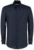 The KK184 by Kustom Kit is a dark blue button-up shirt featuring a chest pocket, long sleeves, and a pointed collar.