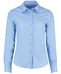 The KK242 by Kustom Kit is a light blue, long-sleeve button-up shirt featuring a collar and cuffs. It is neatly pressed and displayed against a plain white background, showcasing its classic and formal style.