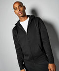 A person wearing a black Kustom Kit KK303 zip-up hoodie stands against a plain background, looking forward.