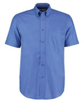 A Kustom Kit KK350 blue short-sleeve button-up shirt featuring a front pocket and a collar.