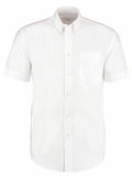 The KK350 by Kustom Kit is a plain white, short-sleeved shirt featuring a button-down collar and a chest pocket, displayed on a white background.