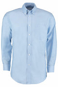 The KK351 by Kustom Kit is a light blue button-up shirt featuring a collar and a chest pocket, neatly displayed on a white background.