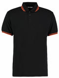 Kustom Kit's KK409 is a black polo shirt featuring orange stripes on the collar and sleeve cuffs.