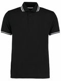 A Kustom Kit KK409 polo shirt in black with white trim on the collar and sleeves, featuring a three-button placket.