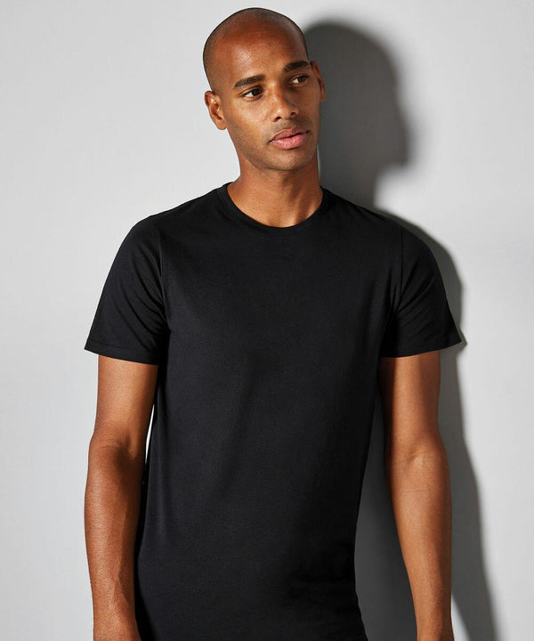 A person standing against a grey background, wearing a plain black KK507 from Kustom Kit. They are looking slightly to the side.