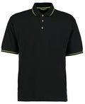 The Kustom Kit KK606 is a black short-sleeve polo shirt, enhanced with green accents on the collar and sleeves, and features a three-button placket.