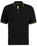 The KK606 by Kustom Kit is a black polo shirt with yellow accents, including a yellow stripe on the collar, yellow trim on the sleeves, and yellow fabric visible behind the black-buttoned placket.