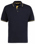 Introducing the Kustom Kit KK606: a black polo shirt featuring striking yellow accents on the collar and sleeve edges. The shirt boasts a stylish collar with a yellow underside and includes three buttons on the placket for added detail.