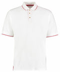 The KK606 by Kustom Kit is a white polo shirt featuring a classic collar with red trim on both the sleeves and collar. It includes a three-button placket and short sleeves, all contributing to its simple, clean design.