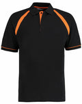 The KK615 polo shirt by Kustom Kit features a black design with orange accents on the shoulders and trim.