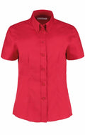 The Kustom Kit KK701 is a vibrant red short-sleeve button-up shirt with a classic collar, showcased against a white background.