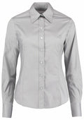 The KK702 by Kustom Kit is a gray, long-sleeved button-up blouse featuring a classic collar. It is elegantly buttoned down the front, showcasing its smooth fabric while displayed on a mannequin against a plain white backdrop.