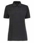 The KK703 by Kustom Kit is a plain black polo shirt featuring short sleeves, a collar, and three buttons down the front. It is displayed against a white background, showcasing its simple and classic design.