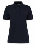 The KK703 by Kustom Kit is a plain black polo shirt with short sleeves and a collar, featuring a three-button placket. Displayed against a white background, the shirt highlights its simple and classic design.