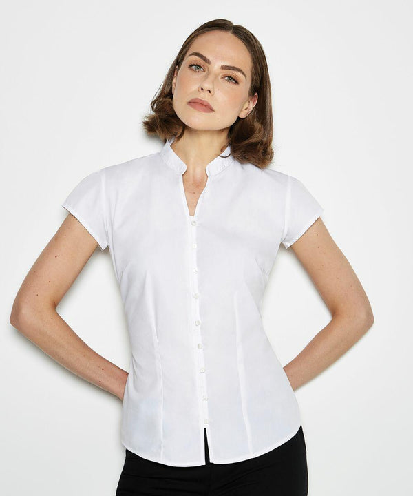 A person wearing a short-sleeved, white KK727 button-up shirt from Kustom Kit and black pants stands against a plain background.