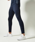 A person stands in a side profile wearing black track pants and KK971 athletic shoes from Kustom Kit against a plain white background.