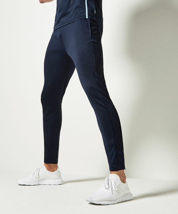 A person stands in a side profile wearing black track pants and KK971 athletic shoes from Kustom Kit against a plain white background.